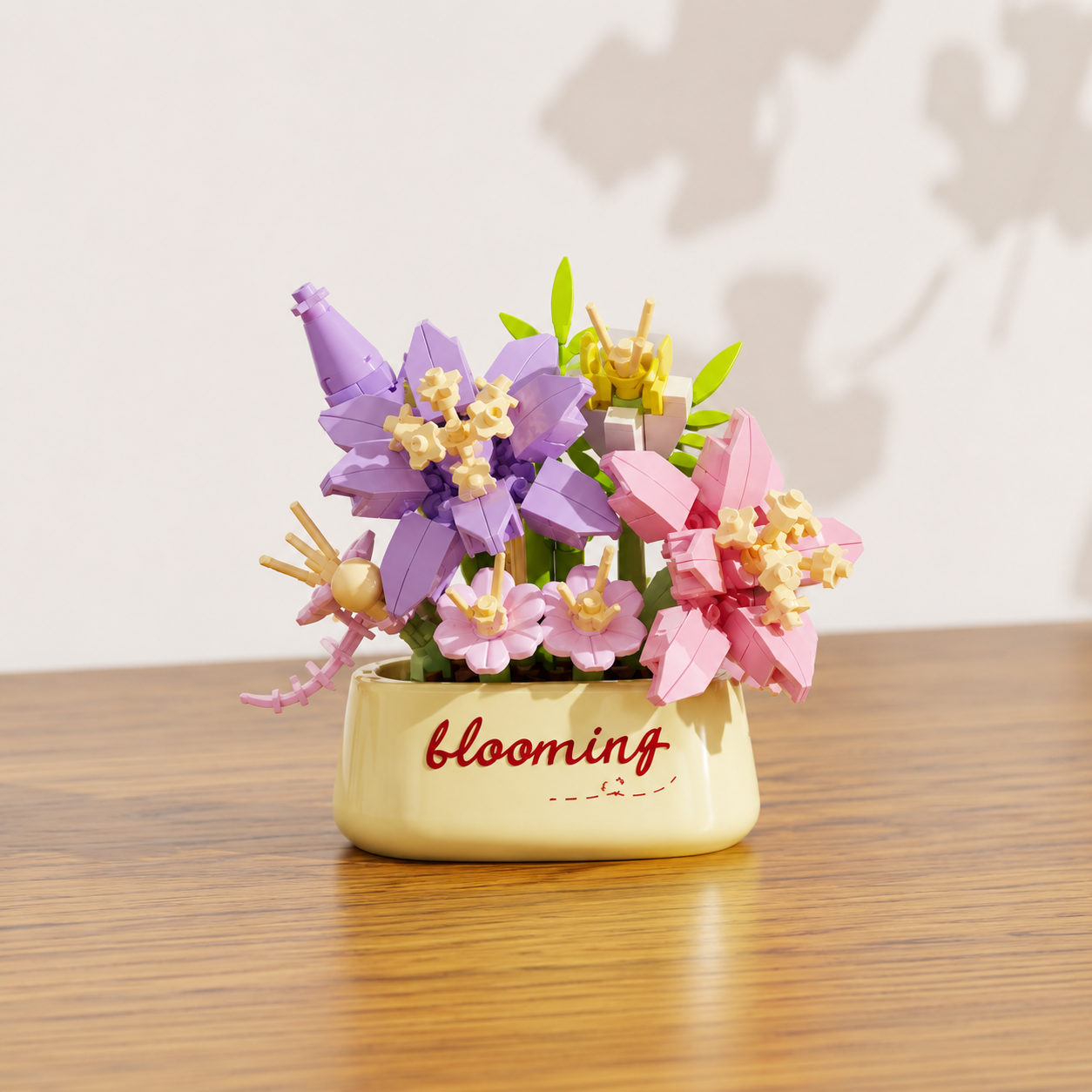 Colorful pink and purple building block flowers, in a pot labeled 'blooming', on a wooden surface.