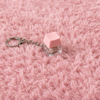 1pc Pink clicky key keychain on a pink textured surface