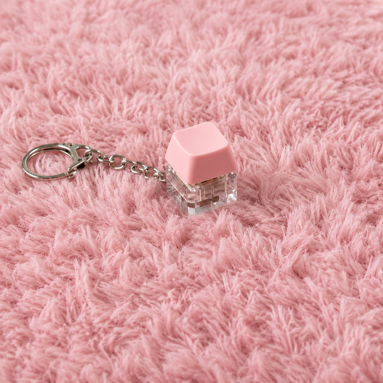 1pc Pink clicky key keychain on a pink textured surface