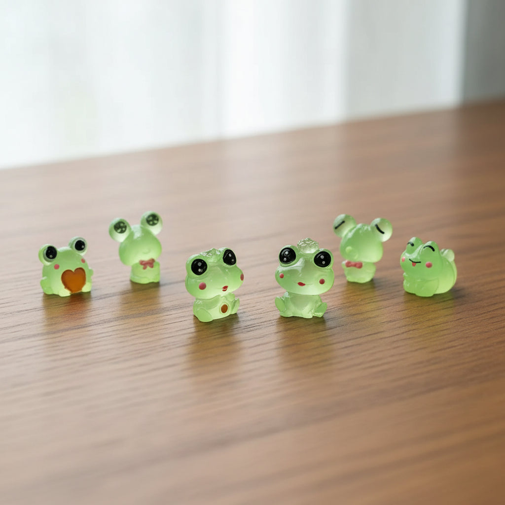 Set of six green frog figurines on a desk