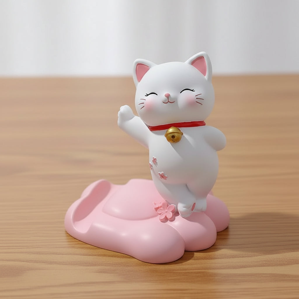 White cat phone stand with pink base on a light surface