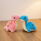 Two plush toy lizards, one pink and one blue, on a light background