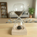 Hourglass with black magnetic sand on a magnetic wooden base in a living room setting
