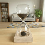 Hourglass with black magnetic sand on a magnetic wooden base in a living room setting