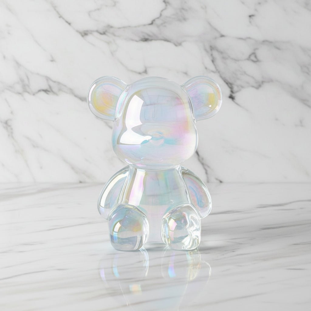 Iridescent glass bear figurine on a light wooden surface