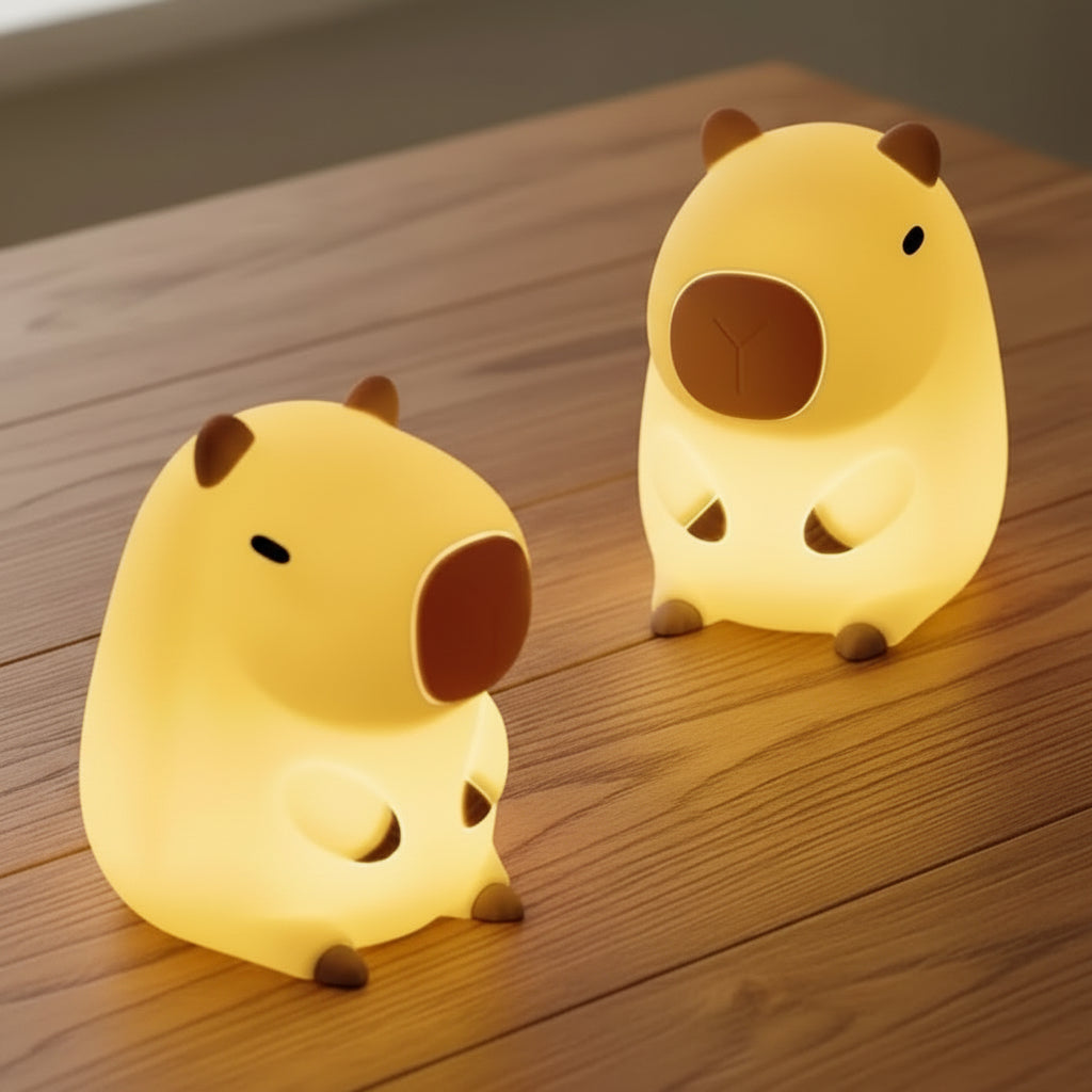 Two yellow animal-shaped night lights on a soft fabric background