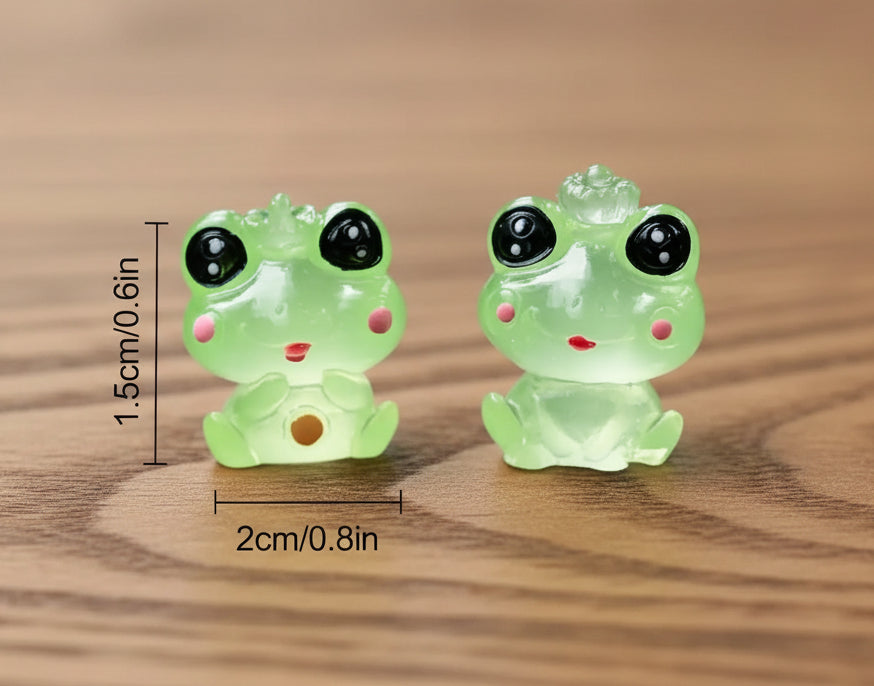 Two green frog-shaped earrings with measurements on a gray surface