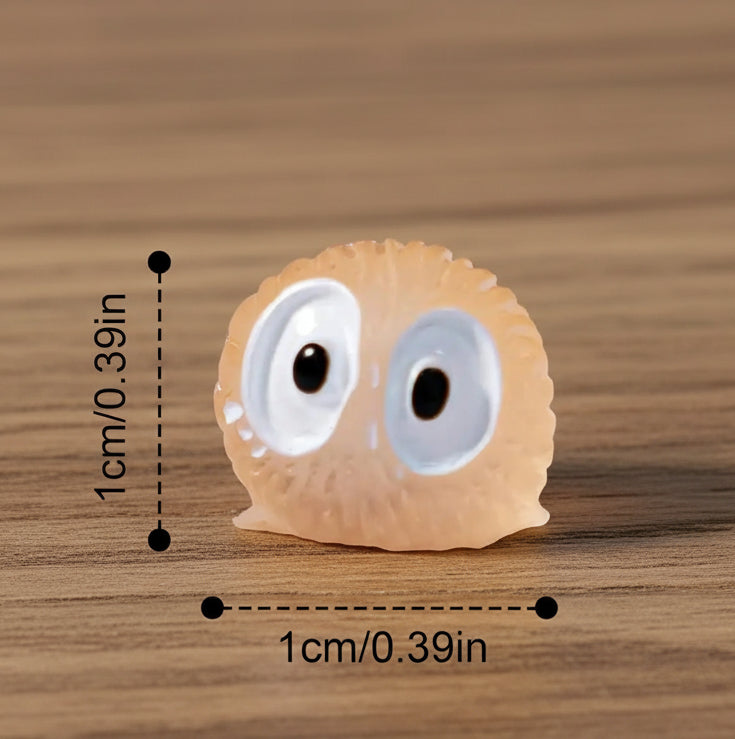 Small decorative item with googly eyes and measurements on a gray background