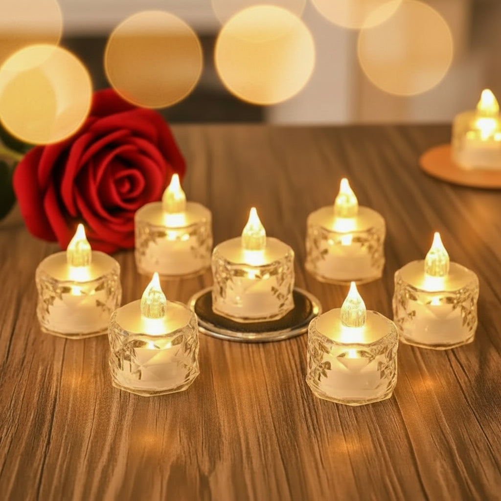 Set of LED candles in glass holders on a wooden base with a red rose in the background.