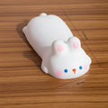 Cute white animal-shaped wrist rest with pink accents on wooden table