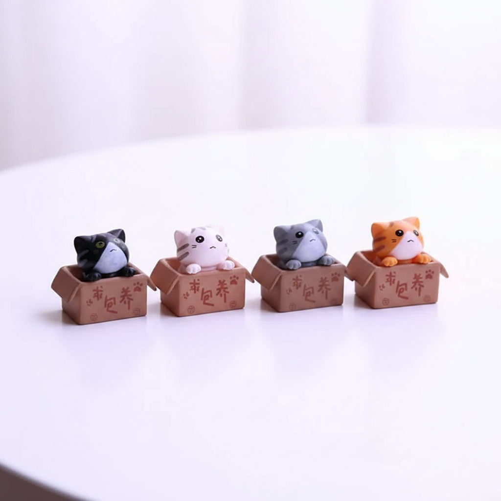 Small cute cat figurines of assorted colours in decorative cardboard boxes 
