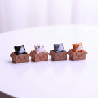 Small cute cat figurines of assorted colours in decorative cardboard boxes 
