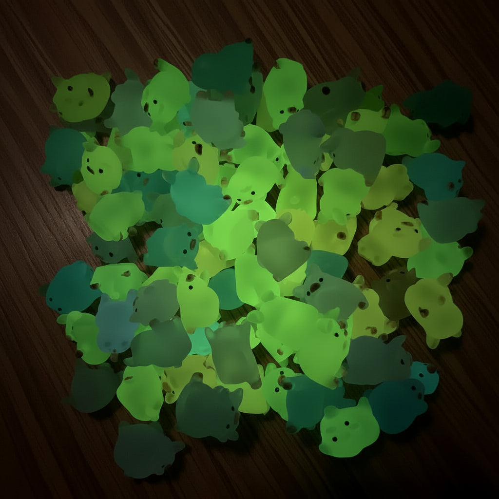 Collection of small, colorful glow in the dark toys with a green glow on a dark background