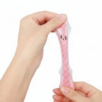 Hand holding a small pink plush toy with a face against a blue background