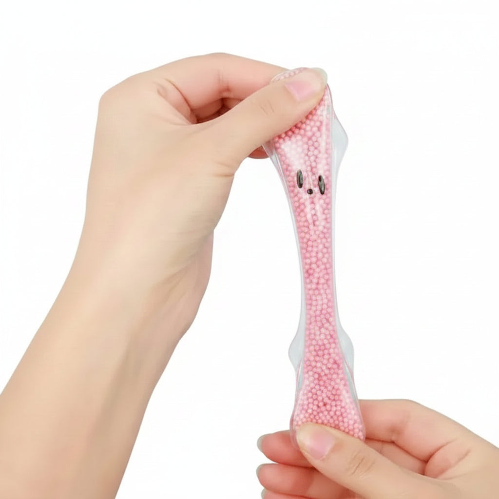 Hand holding a small pink plush toy with a face against a blue background