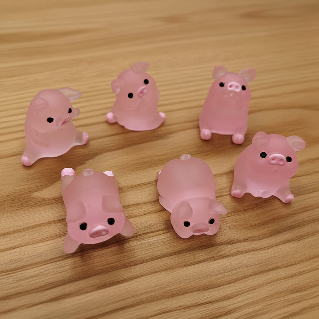 Set of pink pig-shaped figurines on wood table
