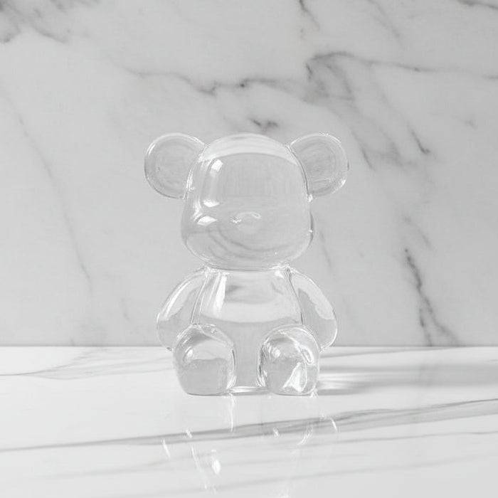 Clear glass bear-shaped object on a marble surface