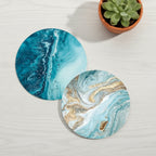 Two marbled coasters with blue and gold design on a light green background with a white flower.