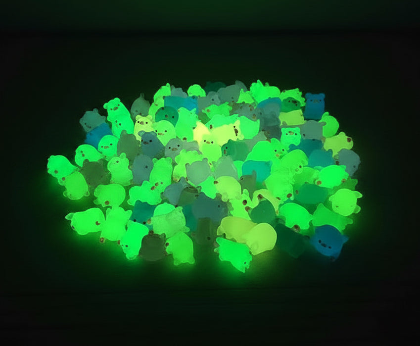 Glowing green and blue animal-shaped toys on a dark surface