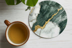 Marble coaster with gold accents on a wooden surface with a plant in the background