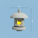 Small japanese inspired stone lantern with a glowing interior on a light blue background, showing dimensions.