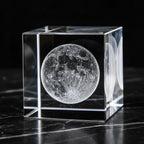 Crystal cube with a moon engraving on a dark surface