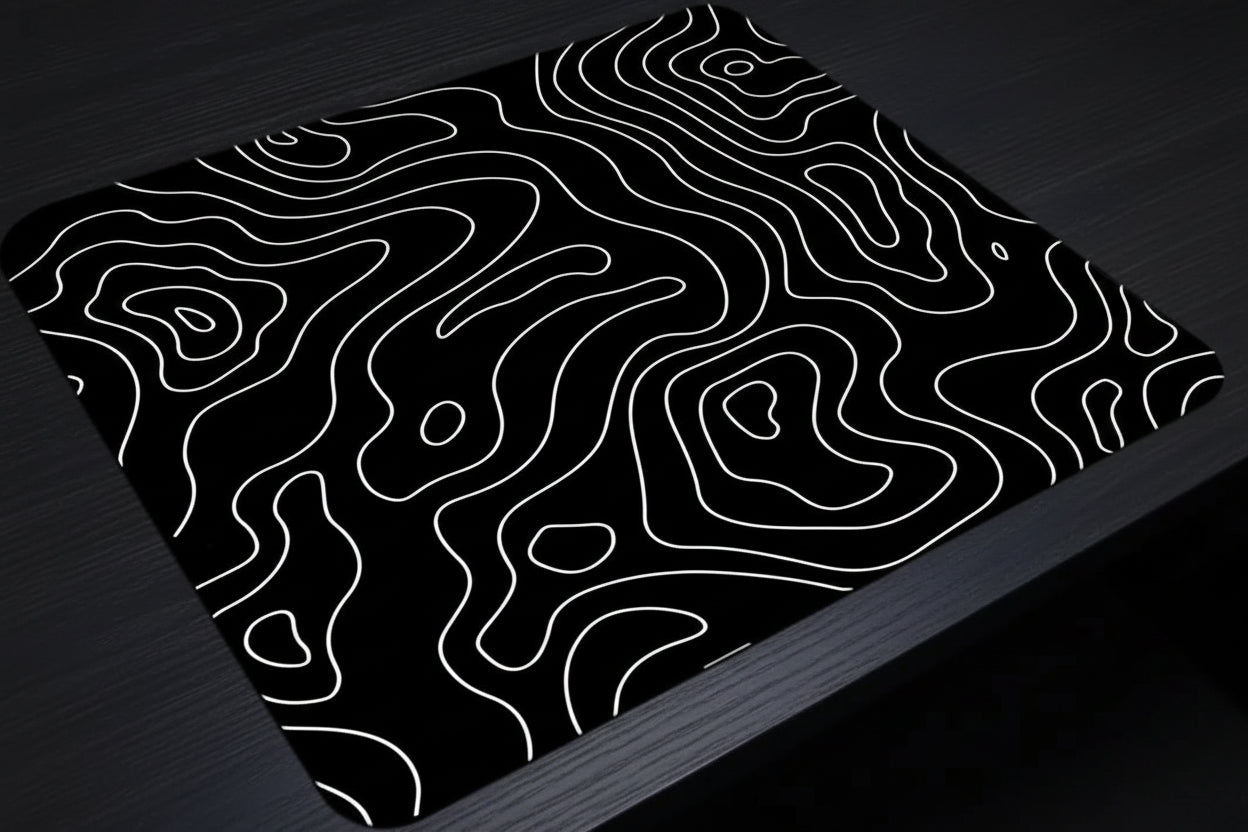 Black surface with white wavy line pattern, possibly a desk or table top.