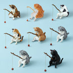 Set of cat figurines in various poses on a light blue background