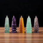 Five crystal towers of different colors on a deske with a black background