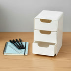 White storage drawers with beige labels on a gray surface