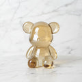 Clear amber-colored bear-shaped object on a marble surface