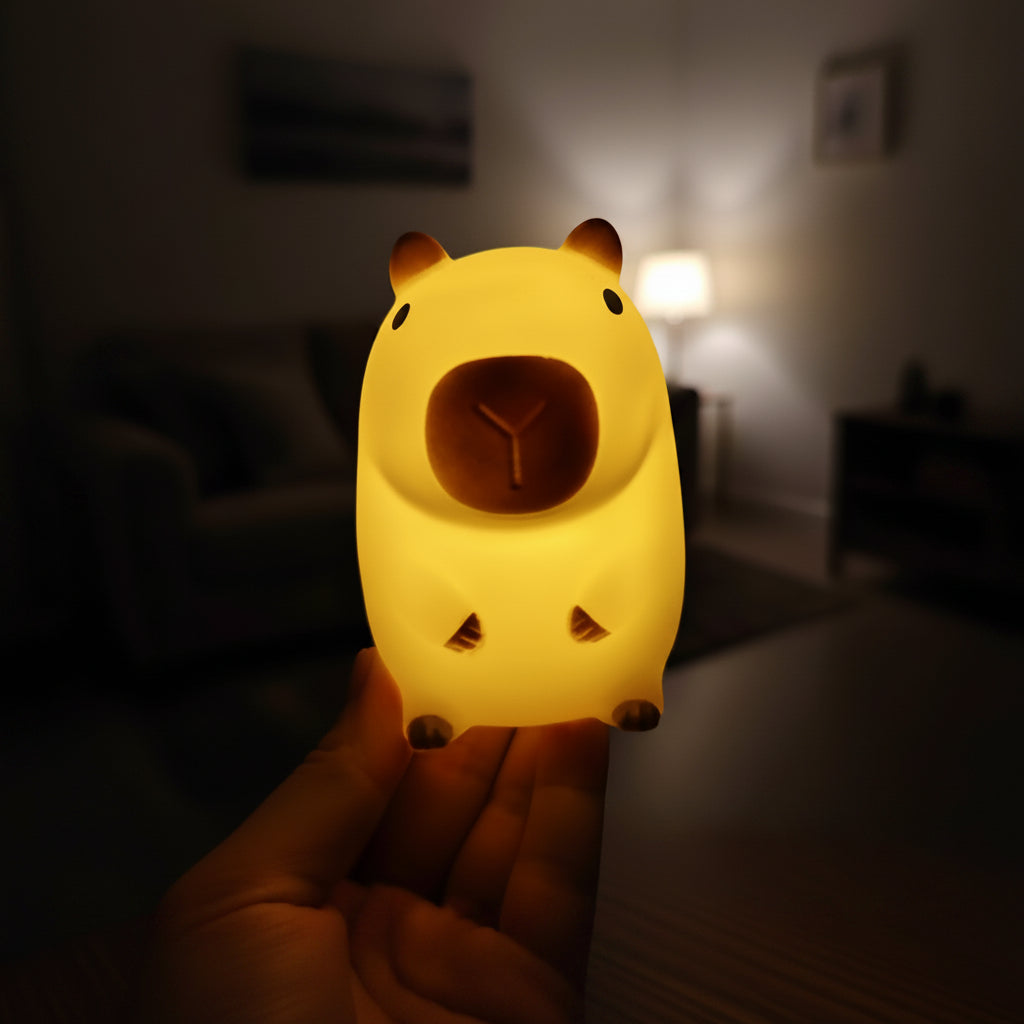 Hand holding a bear-shaped night light with a cityscape in the background