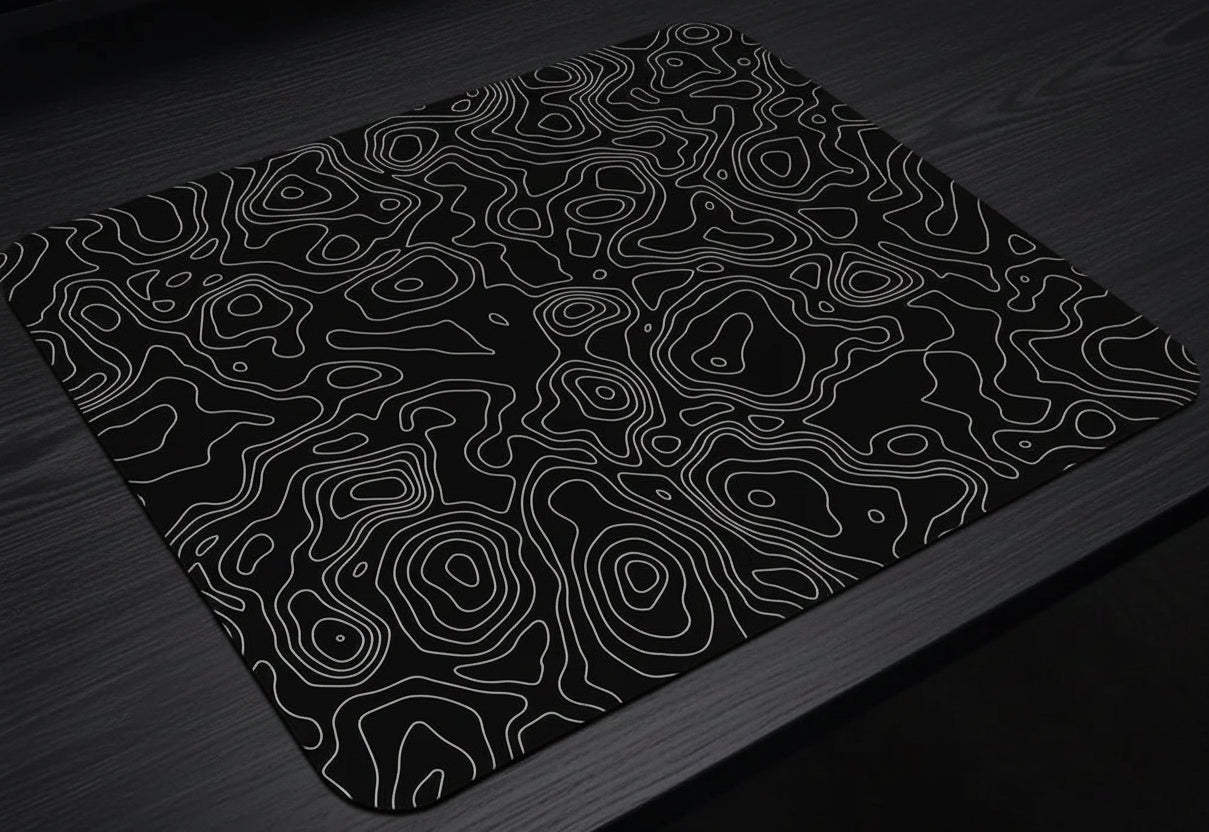 Black mouse pad with white line pattern on a desk