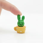 Small and cute green rabbit-shaped cactus in a yellow cup with pure white background
