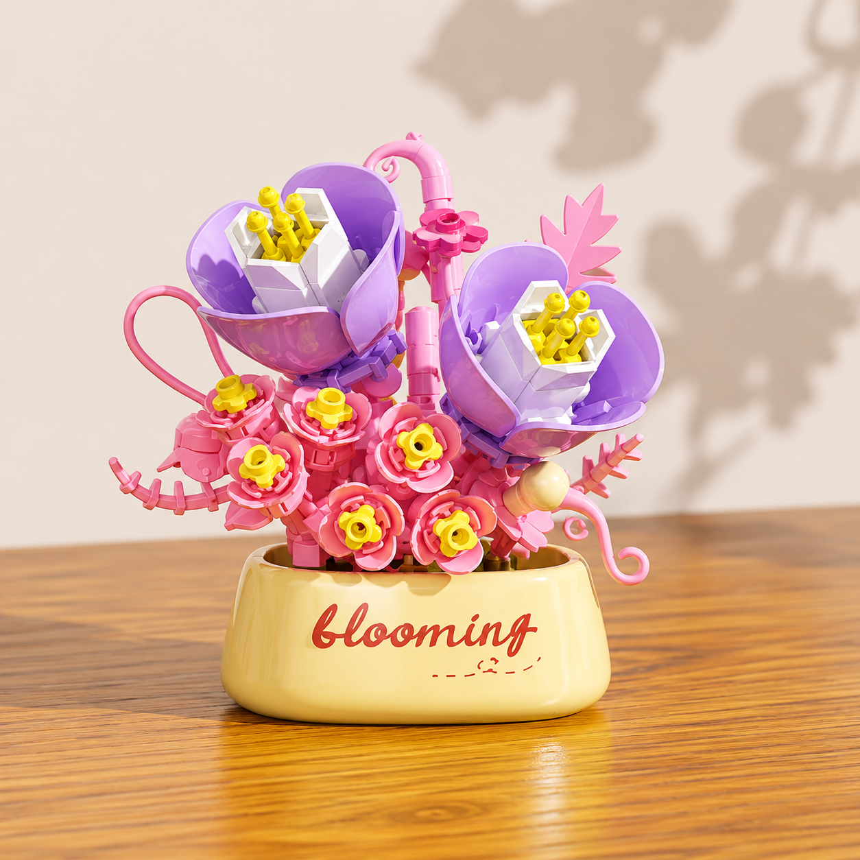 Purple and pink building block flowes with 'blooming' text on a wooden surface